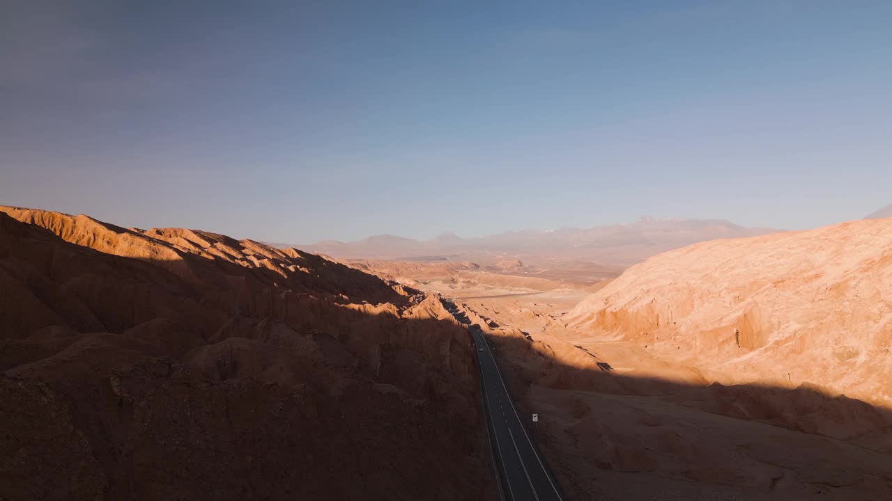 日落时分，沙漠公路穿过智利贫瘠的土地，暖色调主导着景色，鸟瞰图视频素材