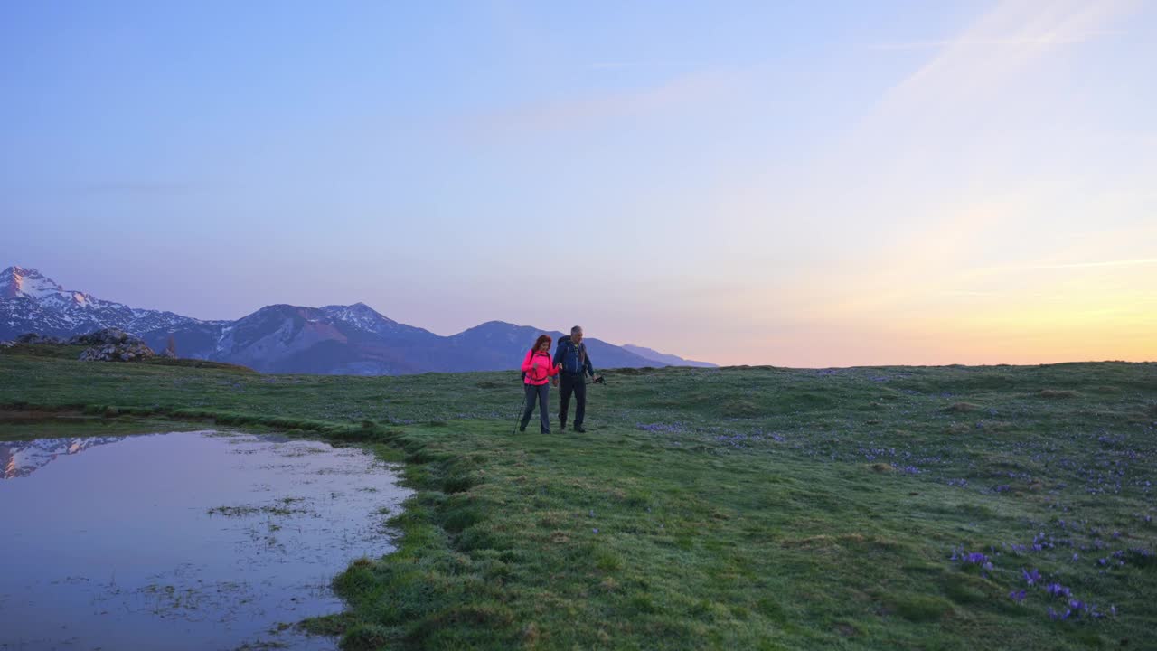 手持登山杖的老年夫妇在日落时分漫步在维利卡·普莱尼纳山景边聊天视频素材