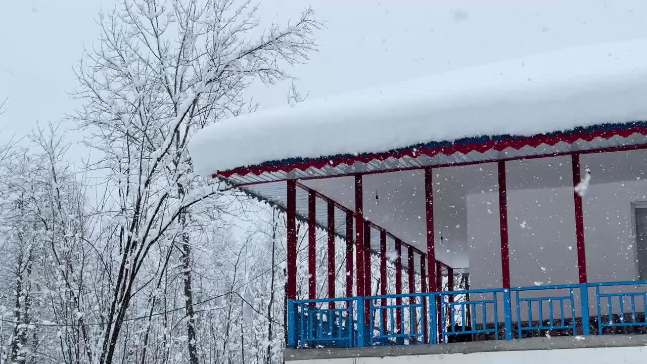 美丽的乡村景观当地人的房子木制彩色建筑红柱柱蓝木栅栏大雪覆盖的屋顶森林自然风景乡村乡村视频素材