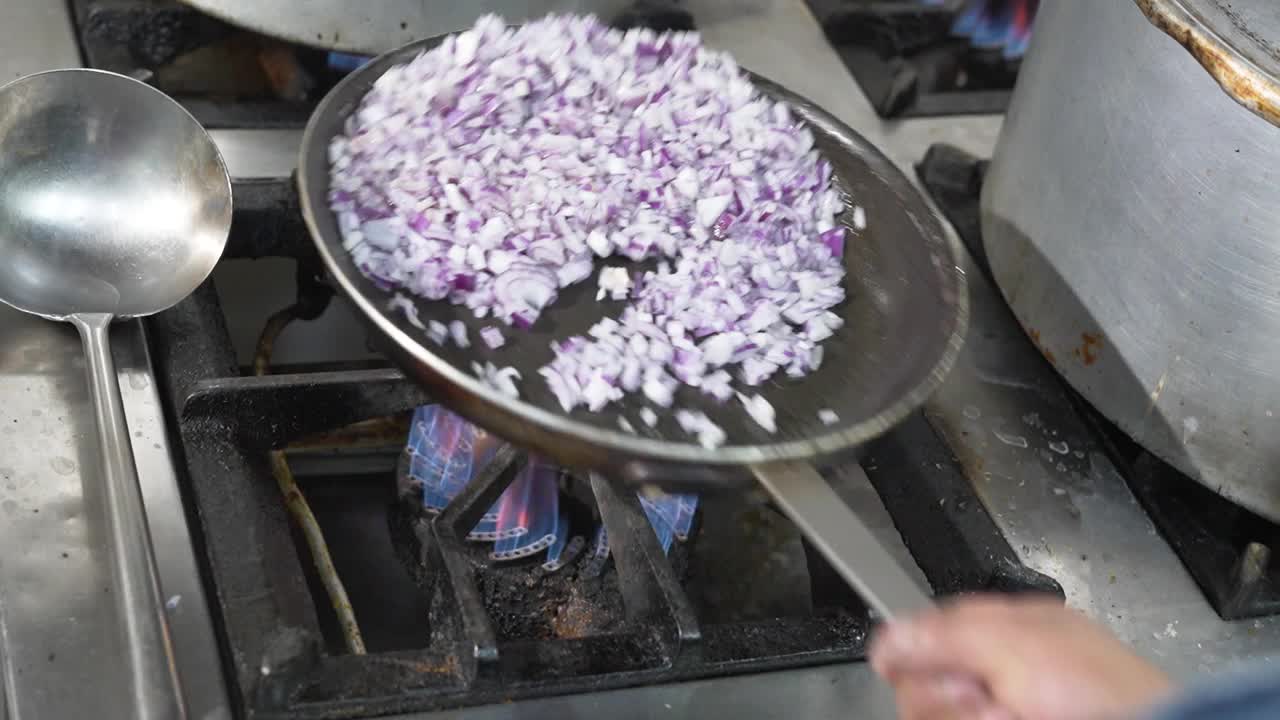 把切碎的洋葱放在火焰上的平底锅里视频素材