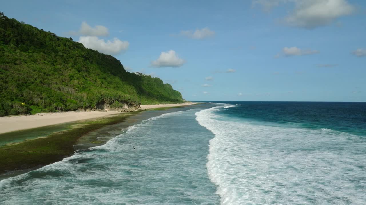 蓝色的海浪冲击着巴厘岛的沙滩和丛林视频素材