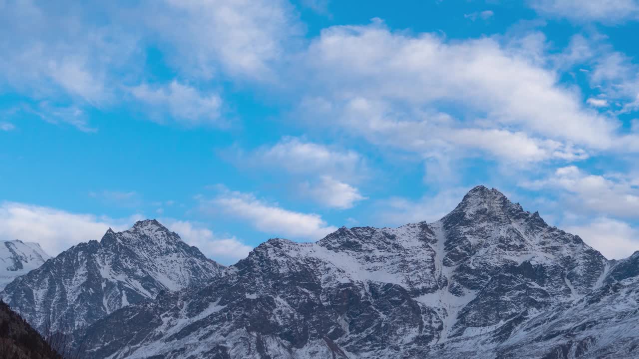 在印度拉胡尔的基隆，用4K延时拍摄的喜马拉雅雪山上的日落，天空中有橙色的云。夏季日落时雪山峰顶的时间差。视频素材