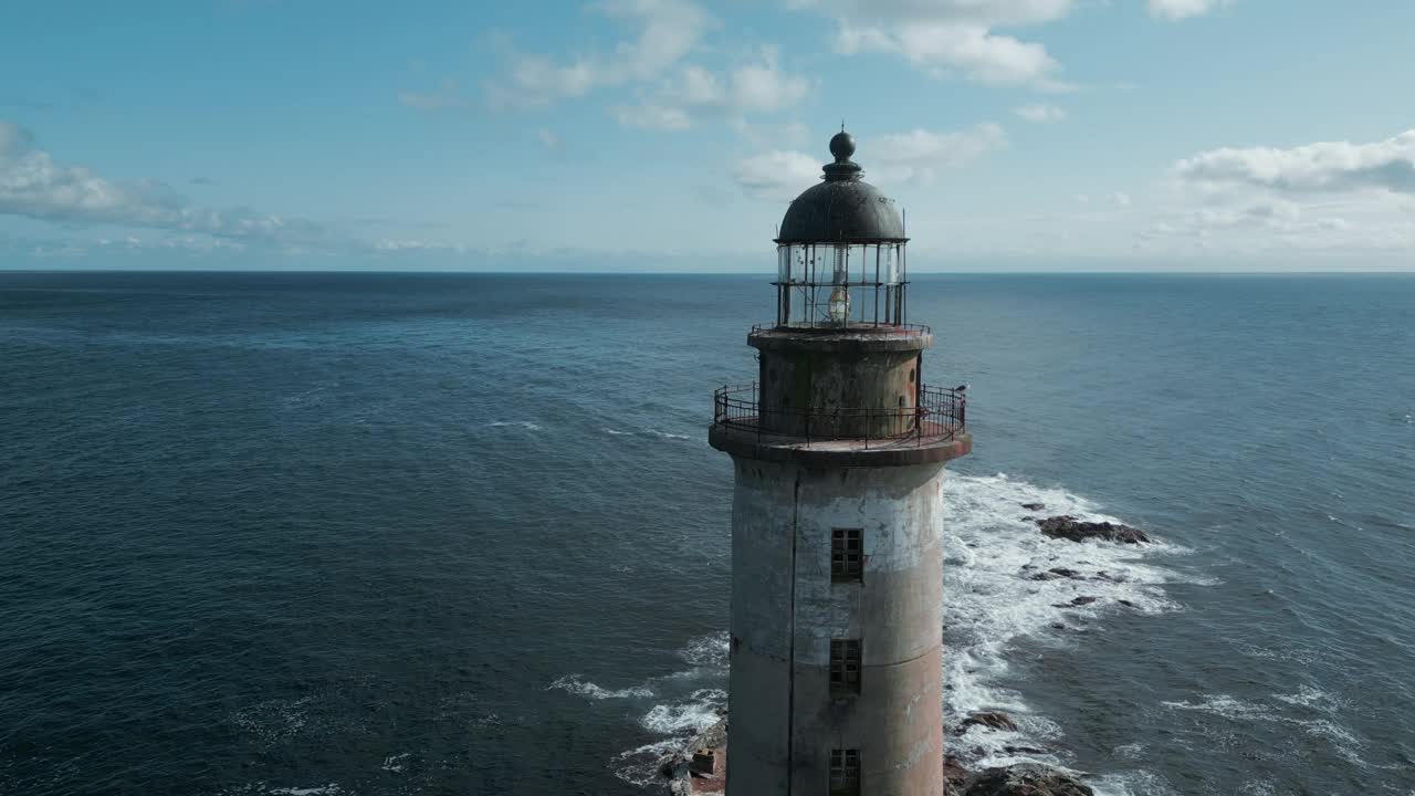 废弃灯塔与海浪的俯视图。夹。在阳光明媚的日子里，海洋中废弃的灯塔令人惊叹的景观。海景，岩石上的废弃灯塔和美丽的蓝色海浪视频素材