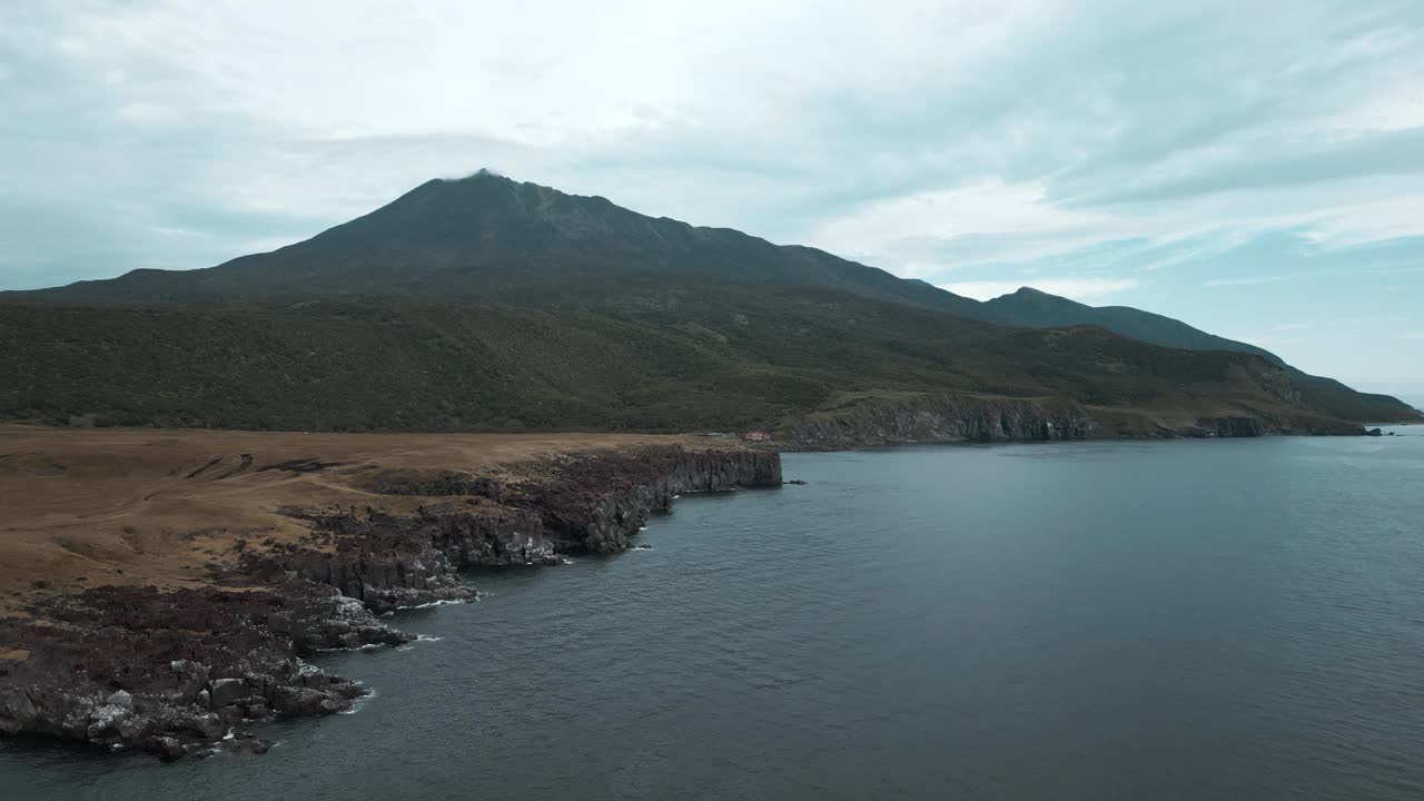 在多云的日子里，以山脉为背景的岩石海岸的俯视图。夹。美丽的北部景观和多云的夏日岩石海岸。山的地平线，多岩石的海岸，多云的天空视频素材