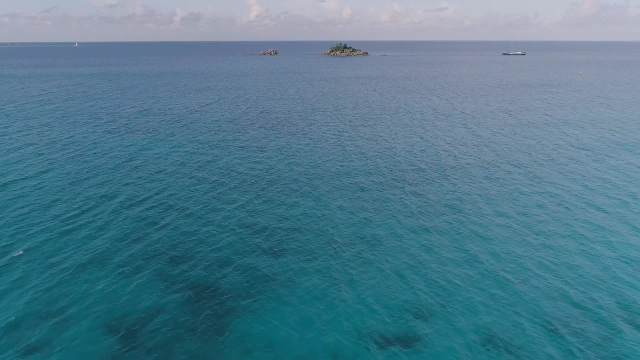 空中岩石岛坐落在海洋中央。水平静清澈，天空湛蓝。这是一片宁静祥和的景象视频下载