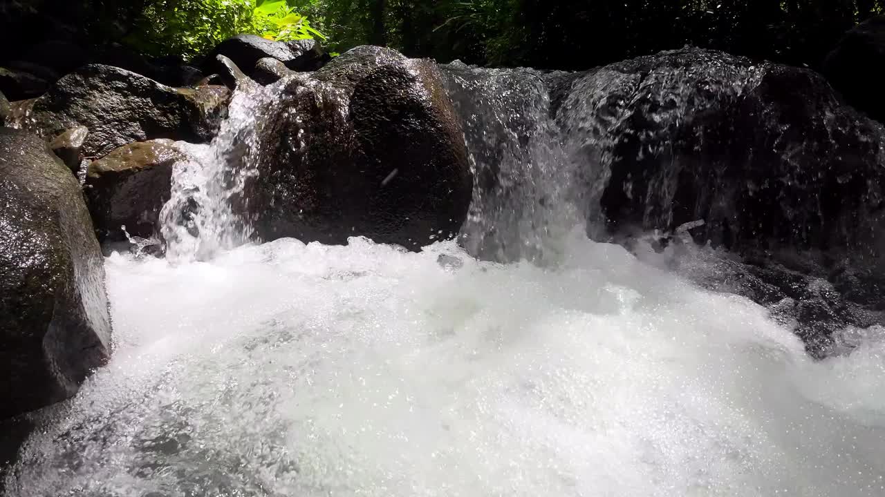 温柔的跟踪拍摄通过风景如画的河流与雄伟的瀑布和巨大的石头，捕捉到令人印象深刻的慢动作，4k分辨率视频下载