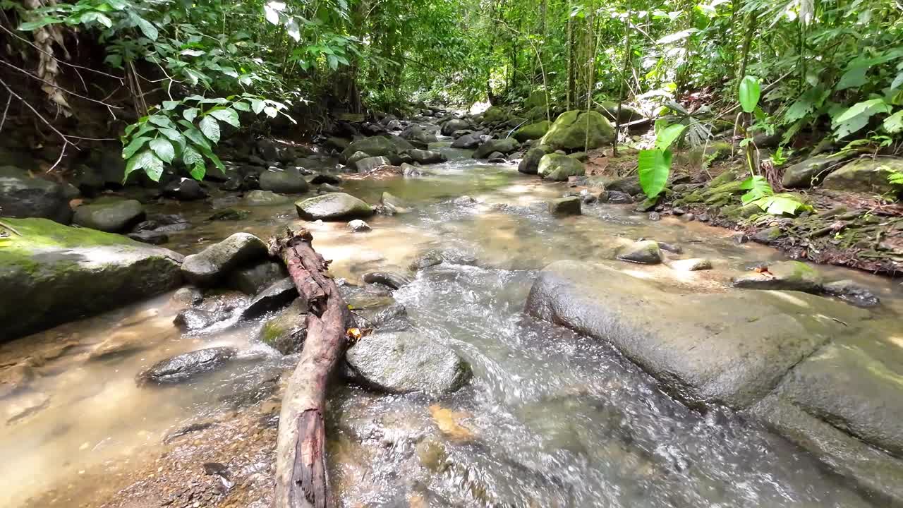 温和的跟踪拍摄通过一个风景如画的河流与雄伟的瀑布和大石头4K分辨率视频素材