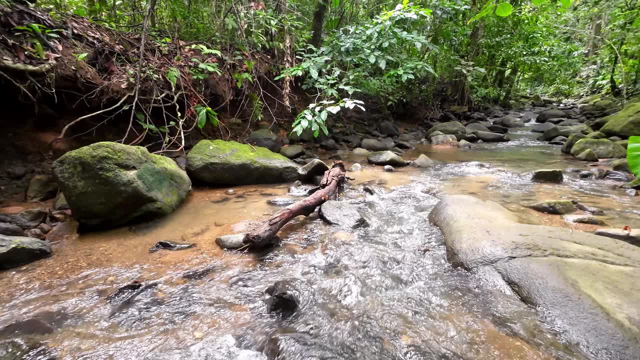 温和的跟踪拍摄通过一个风景如画的河流与雄伟的瀑布和大石头4K分辨率视频素材