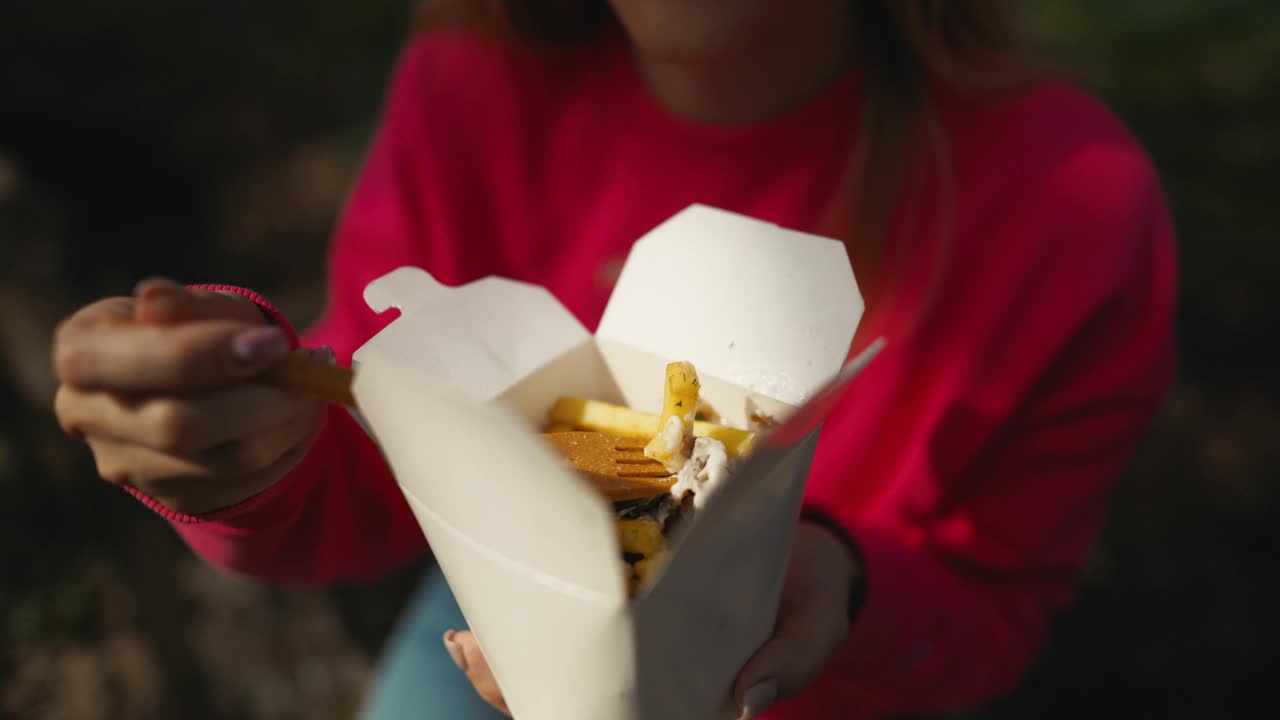 图为，一位女士在活动现场与餐具共用一道菜，正在享受美食视频素材