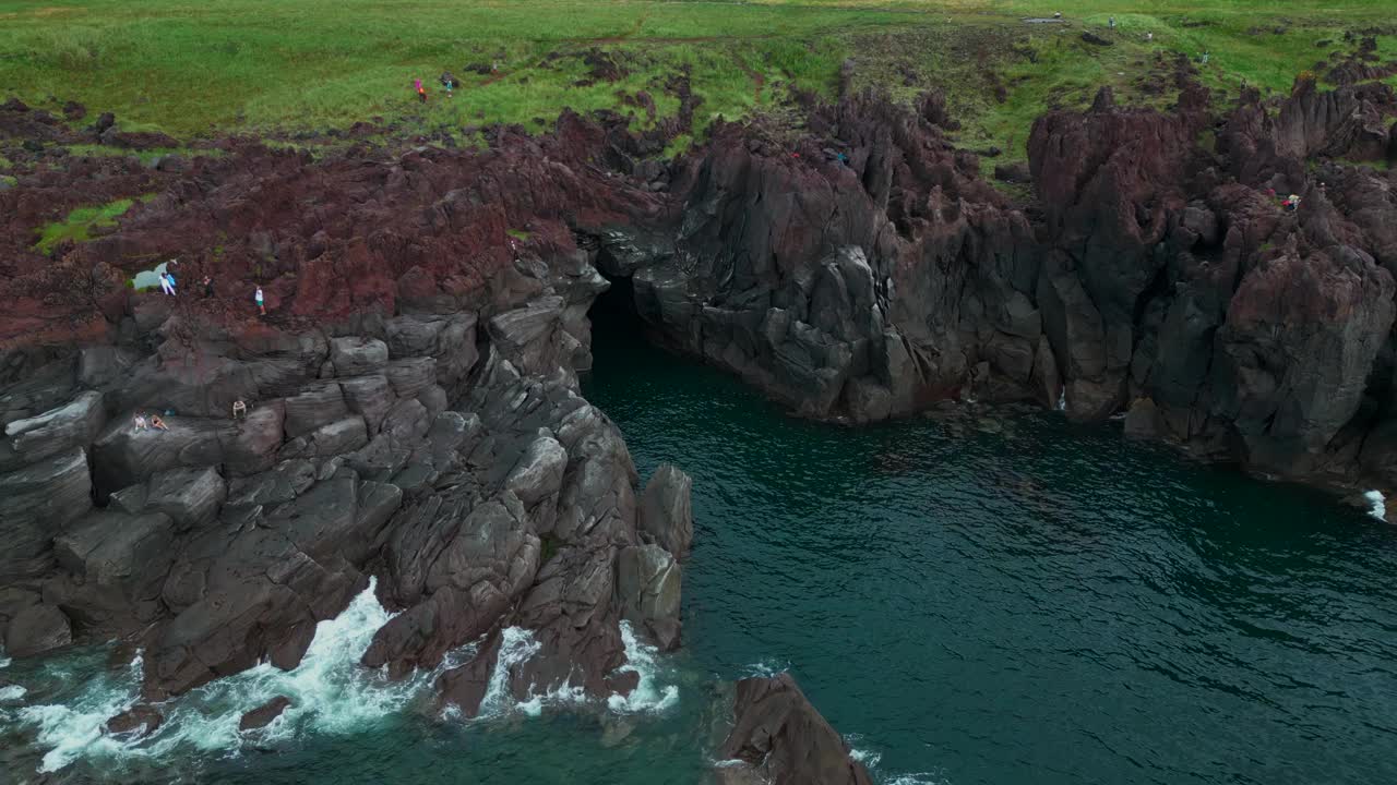 岛上悬崖和碧海的壮丽景色。夹。飞近那个不知名的小黑暗洞穴。视频素材