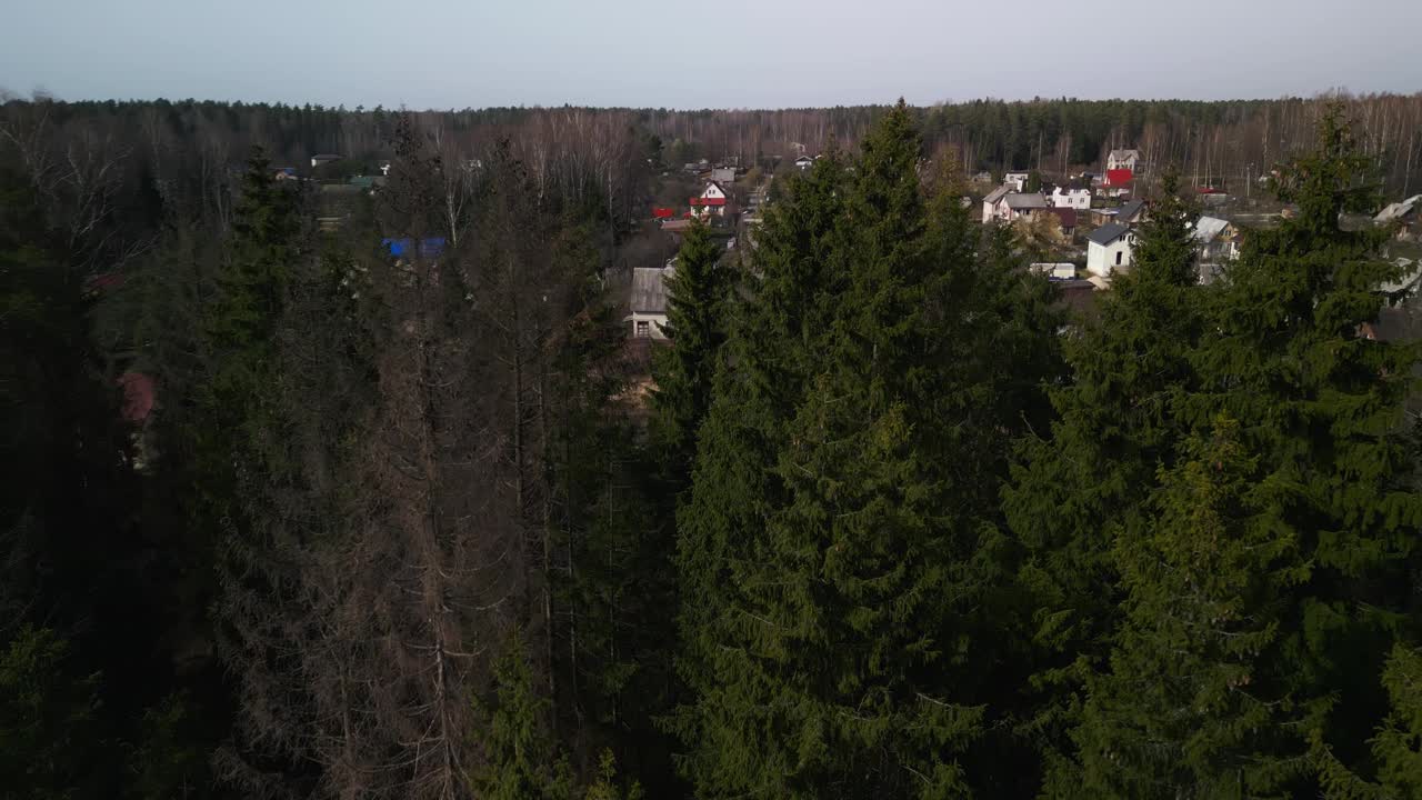 一个村庄坐落在一片绿树成荫的风景下，天空中充满了云彩视频素材