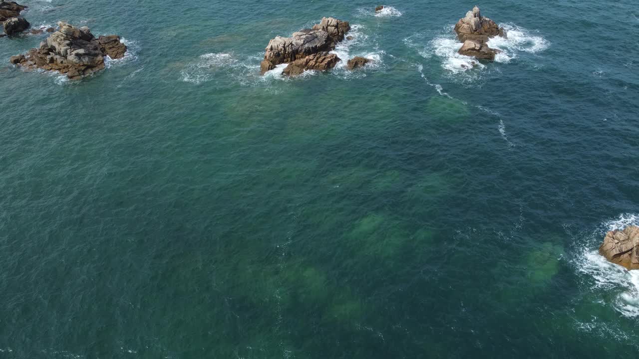 空中无人机拍摄的蓝色海浪撞击岩石山崖的图片。海浪危险视频下载