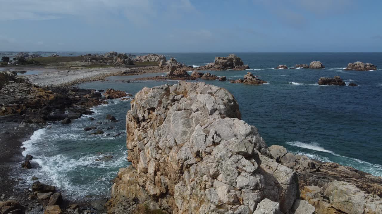 海浪在蓝色的海洋中冲破岩石的鸟瞰图。海浪在美丽的鸟瞰图的海滩无人机拍摄。鸟瞰海浪撞击空岩石的画面视频下载