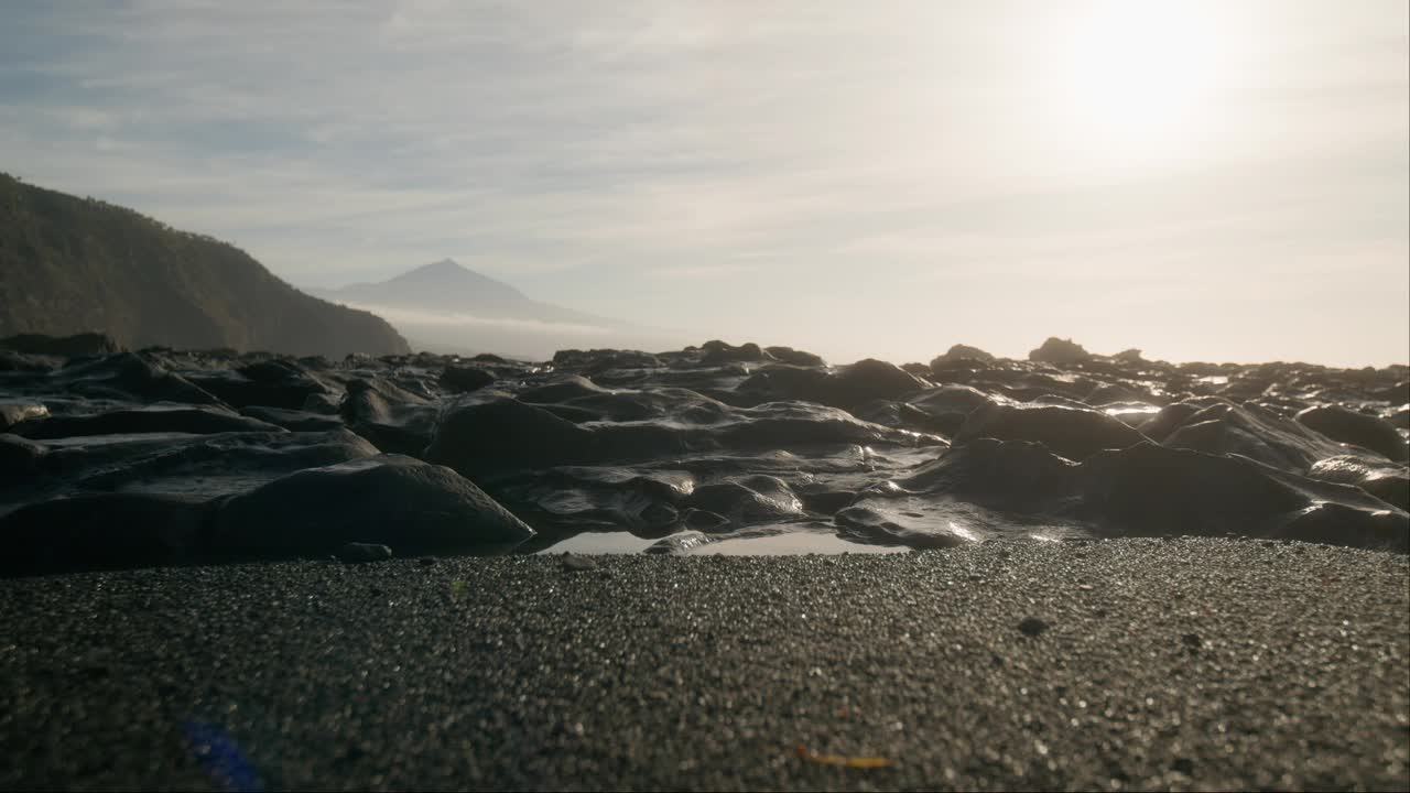 加那利群岛，黎明时分缥缈的特内里费海滩，黑色的沙滩和火山岩，背景是薄雾笼罩的泰德皮科视频素材