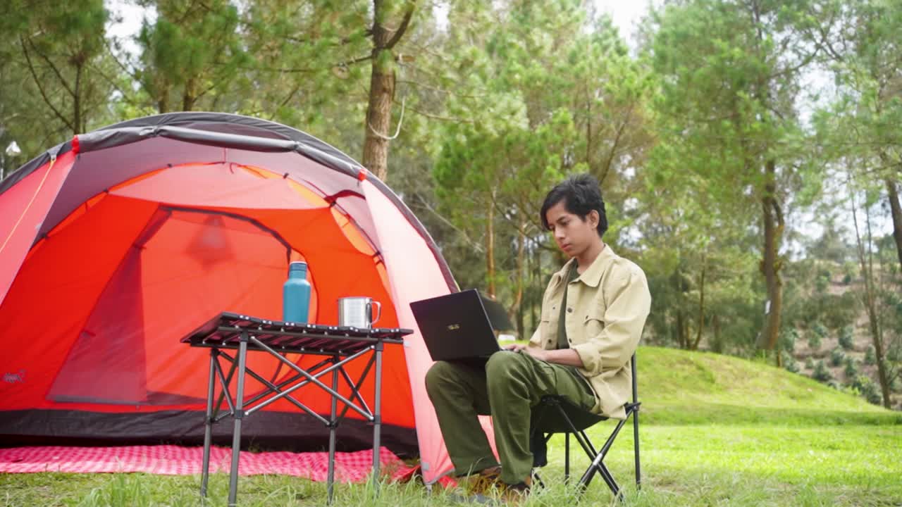 十几岁的男孩在帐篷里用笔记本电脑视频素材