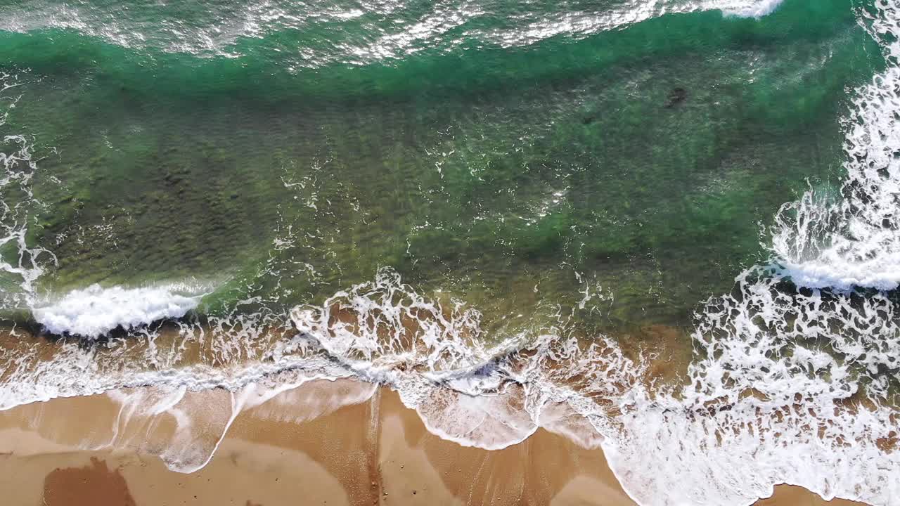 从无人机的角度来看，清澈的海浪冲击着沙滩，大自然的慢动作视频下载
