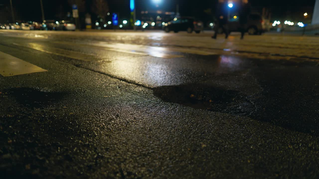 人们在昏暗的路灯下穿过柏油路的夜景视频素材