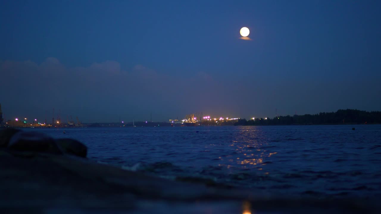 满月在夜晚从水面升起，营造出迷人的氛围视频素材