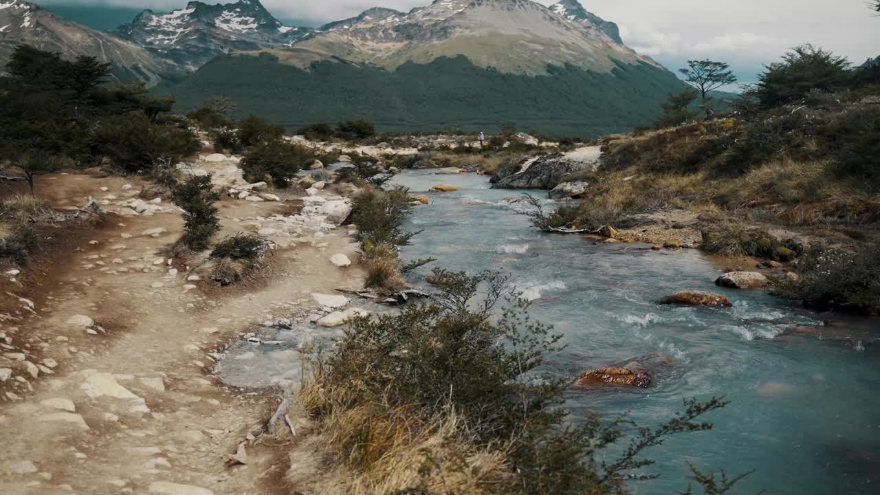 在阿根廷火地岛乌斯怀亚，沿着远足路线到拉古纳埃斯梅拉达的岩石溪流。-手持拍摄视频素材