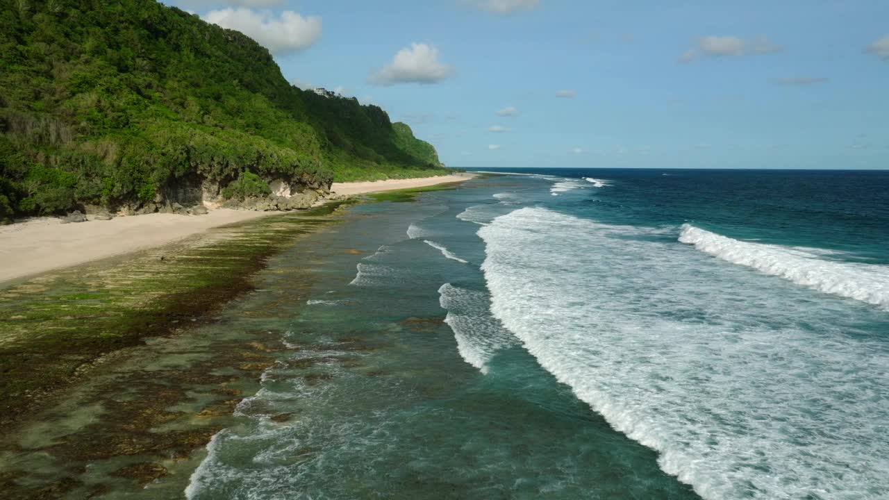 蓝色的海浪冲击着巴厘岛的沙滩和丛林视频素材