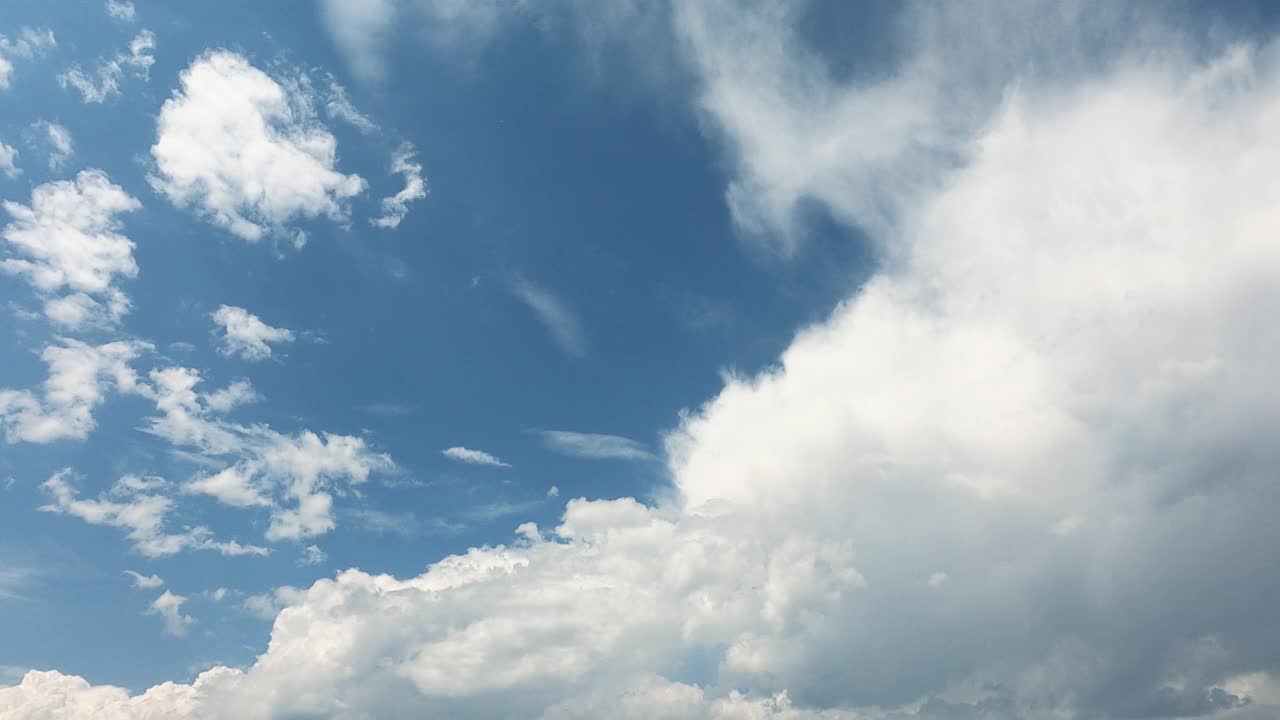 蓬松的白云在蓝色的夏日天空背景中移动。天上的天空令人放松的风景。春季天气条件好，适合户外活动。自然背景和环境概念。视频素材