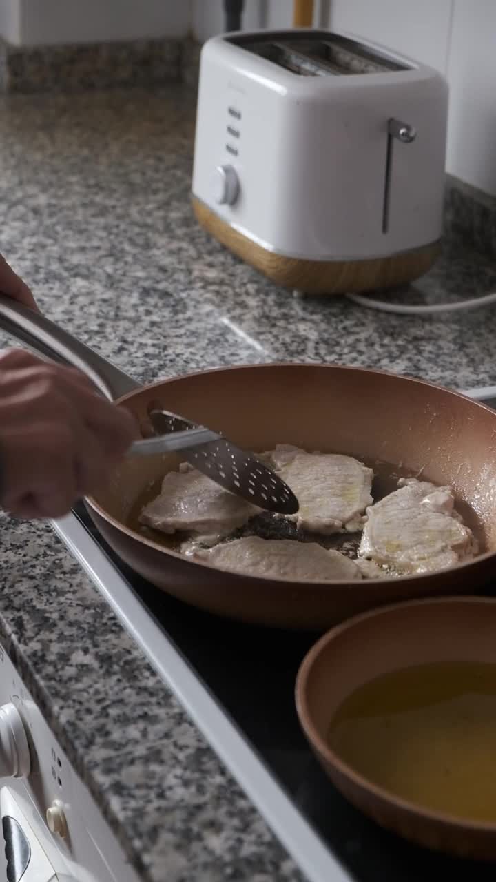 一位妇女在厨房里做饭。真实的人。视频下载