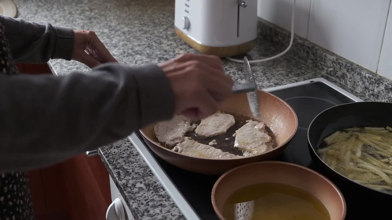 一位妇女在厨房里做饭。真实的人。视频下载