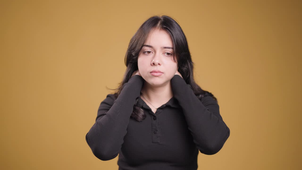 年轻女子表示关切和困惑，双手捂脸，背景扎实视频素材