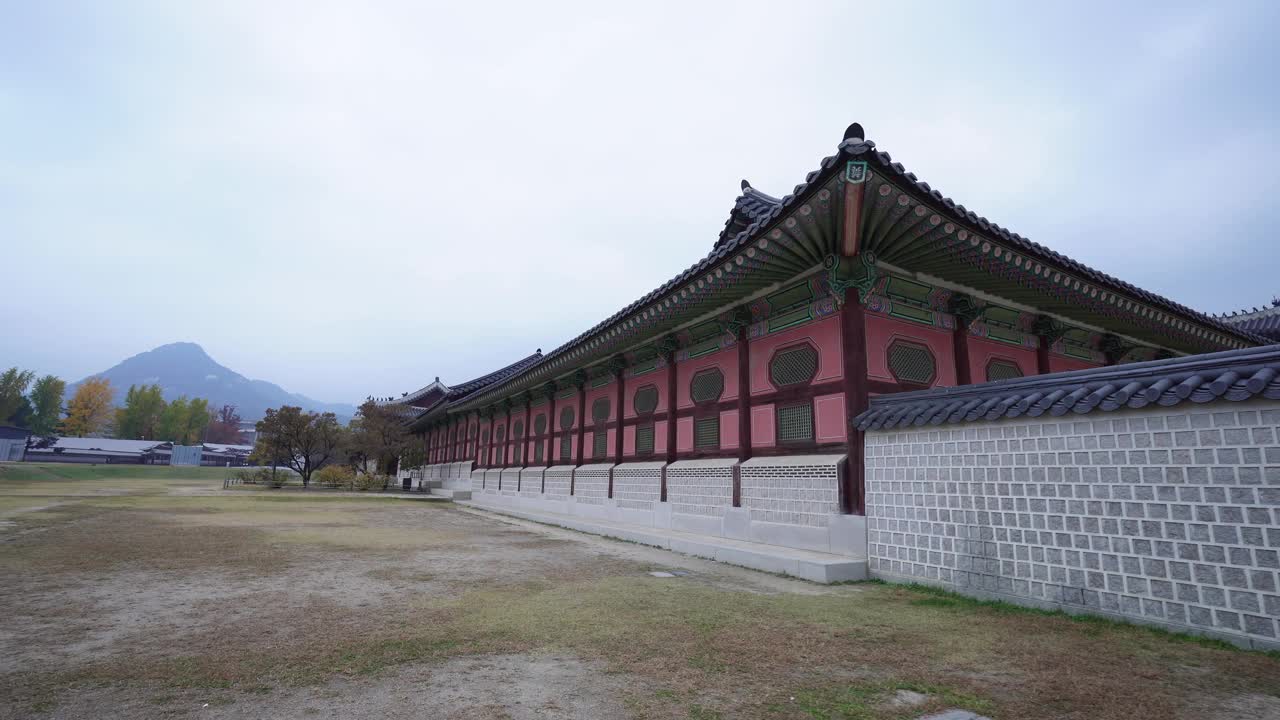 位于首尔景福宫的韩国传统建筑，在多云的天空下，以山为背景，设计复杂，色彩鲜艳视频素材