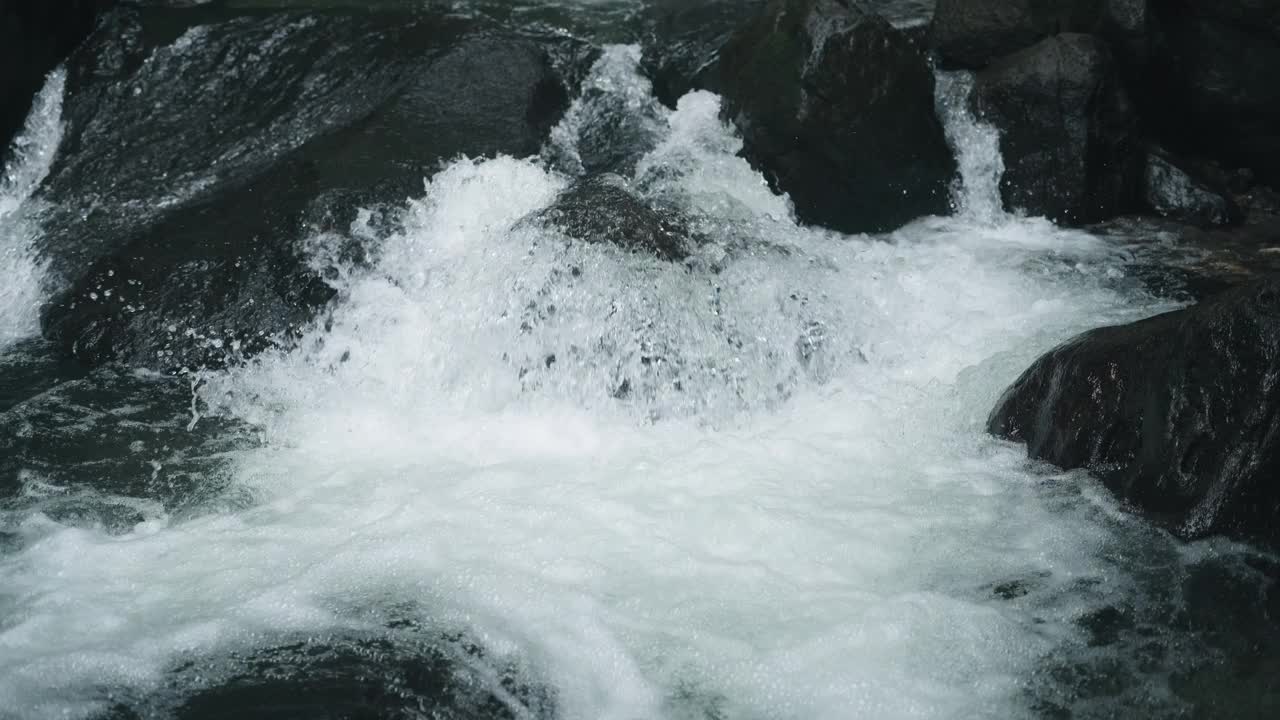 山野河水流过巨石。溪水丰富清澈。激流附近的冷水飞溅。国家公园里岩石上的小瀑布。水背景概念视频素材