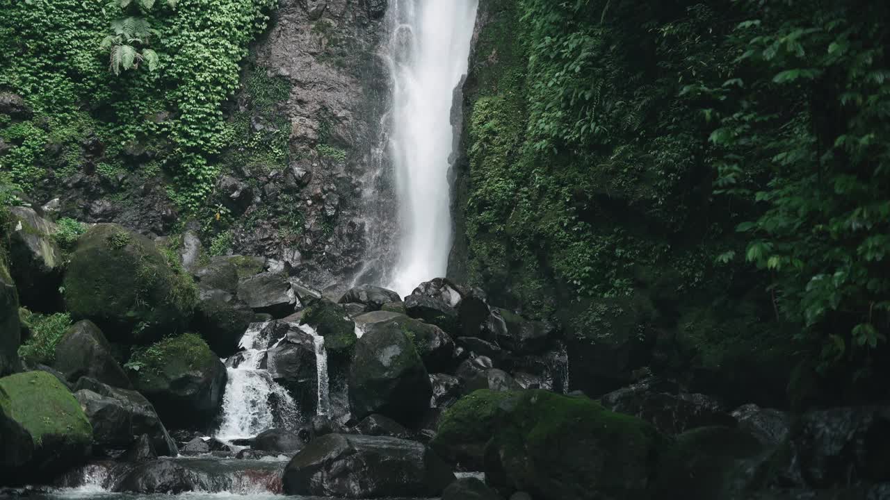 清澈的水从雨林中的瀑布倾泻而下视频素材