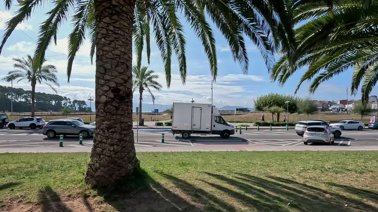 汽车沿着大街行驶，人们在海边散步视频下载