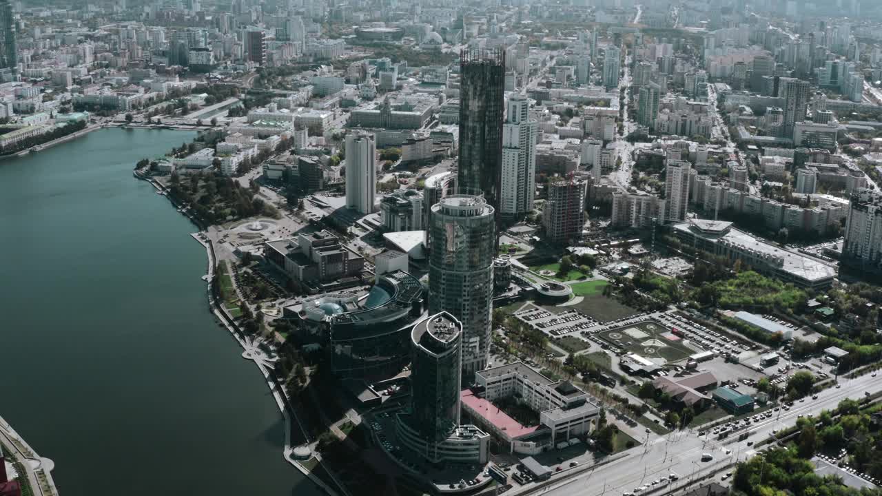 阳光下的建筑城市。资料片。巨大的玻璃办公室和住宅楼矗立在湖边和步行区旁边。视频素材