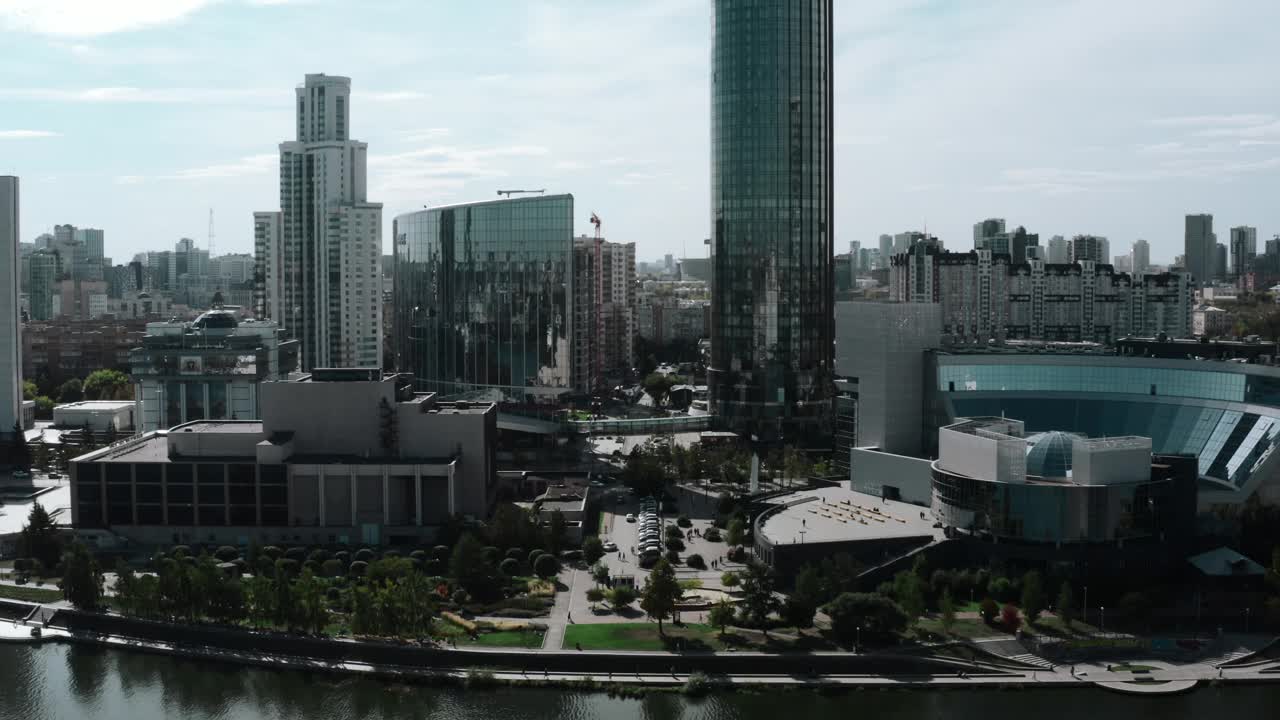 从直升机上拍摄的日间风景。资料片。一个巨大的城市的明亮的视野，有高楼大厦，办公室位于池塘和公园旁边。视频素材