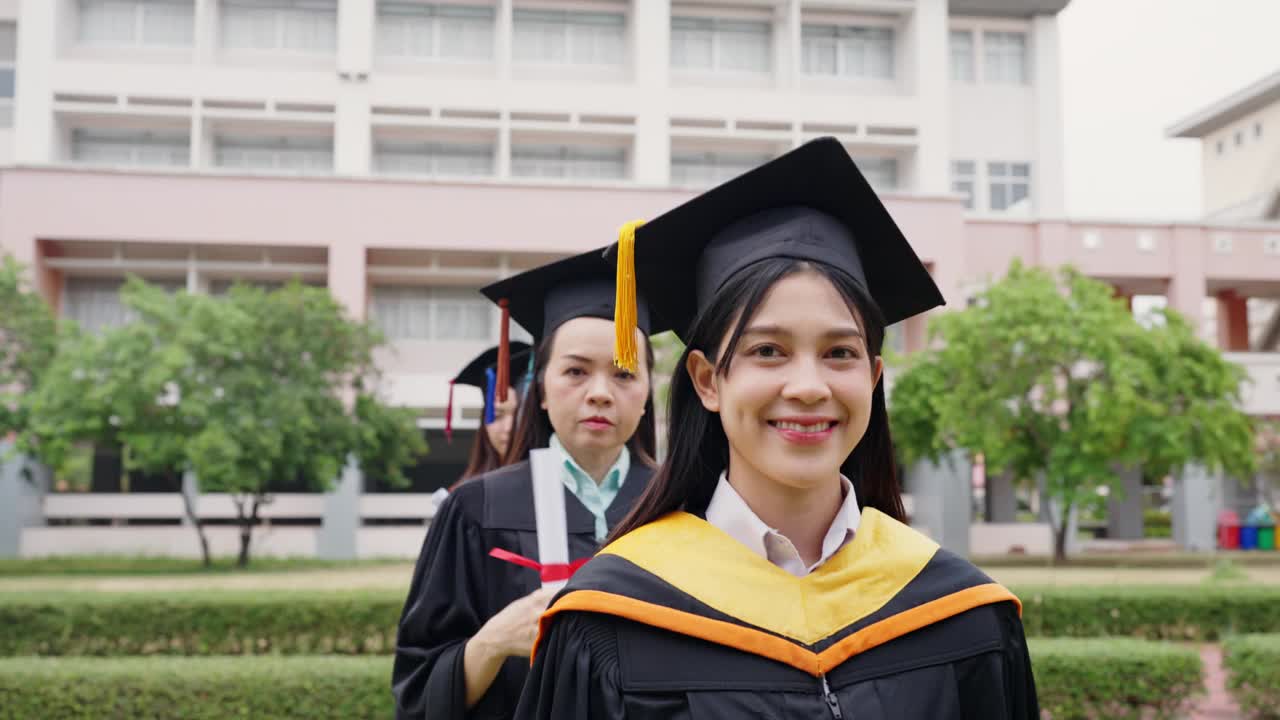 两个穿着毕业礼服的女人对着镜头微笑视频素材