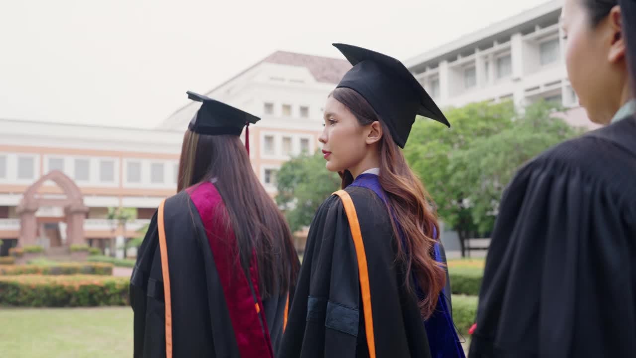 三个穿着毕业礼服的女人一起走着视频素材