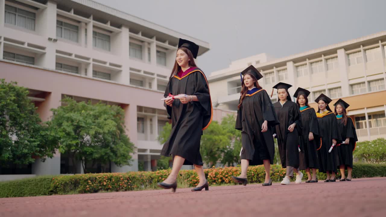 一群穿着毕业礼服的女生走在砖砌的人行道上视频素材