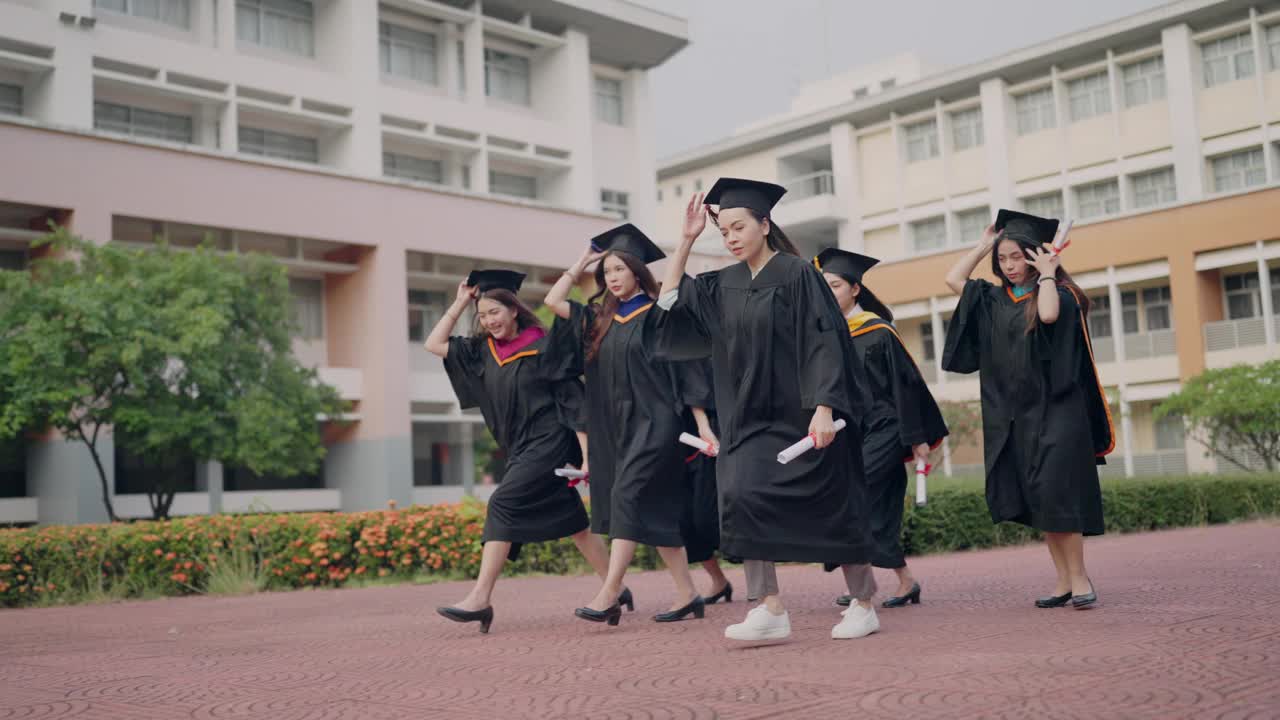 一群穿着毕业礼服的女生走在红砖人行道上视频素材