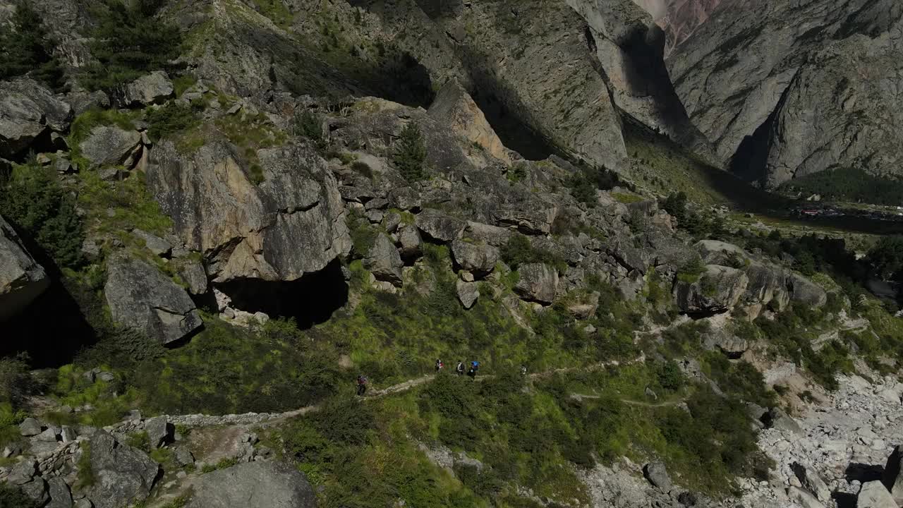 空中无人机拍摄的4名徒步旅行者在青山上爬山的画面视频素材