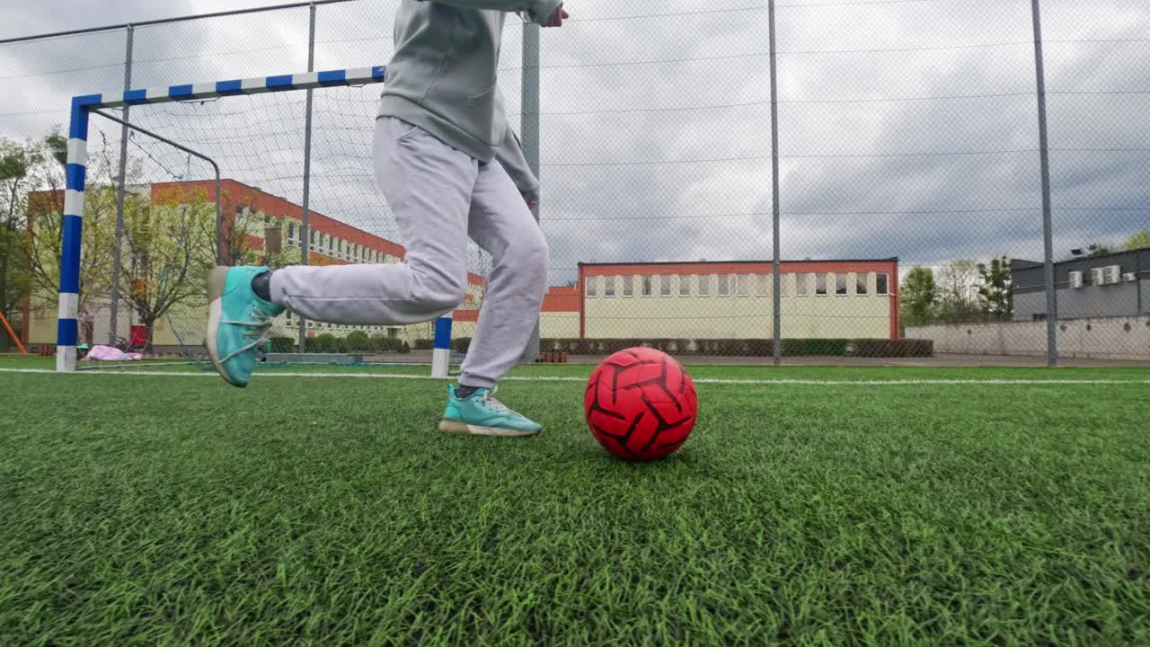 孩子在踢足球，在足球场上带球训练视频素材