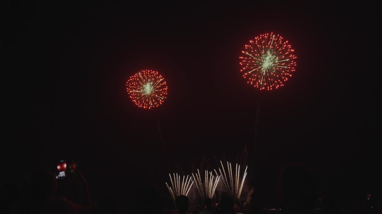 璀璨的烟花在芭堤雅的海面上绽放，在一个欢乐的庆祝之夜，创造了令人眼花缭乱的光和色彩。视频素材