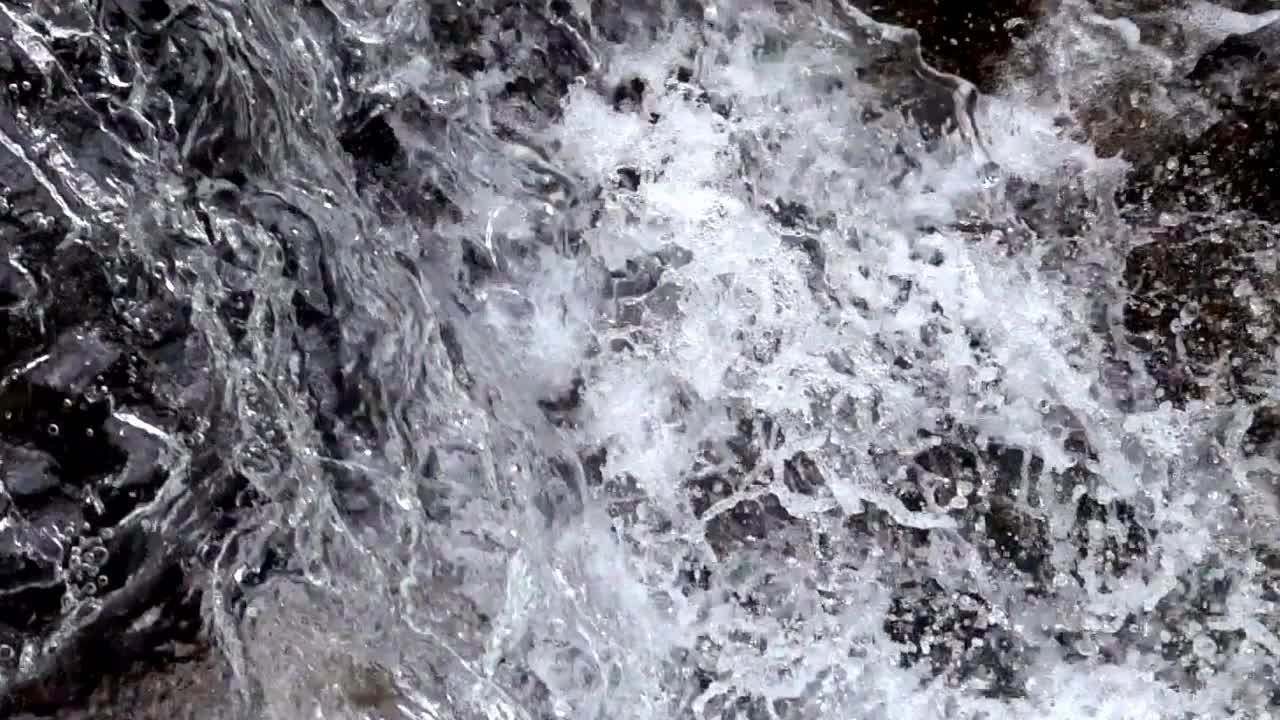 一个有飞溅水滴的动态水面的特写视频下载