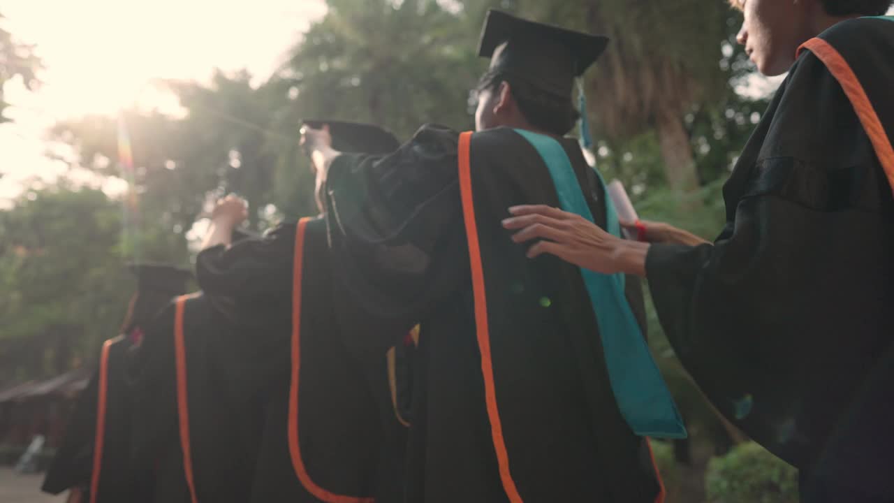一群毕业生站成一排，戴着帽子，穿着长袍视频下载