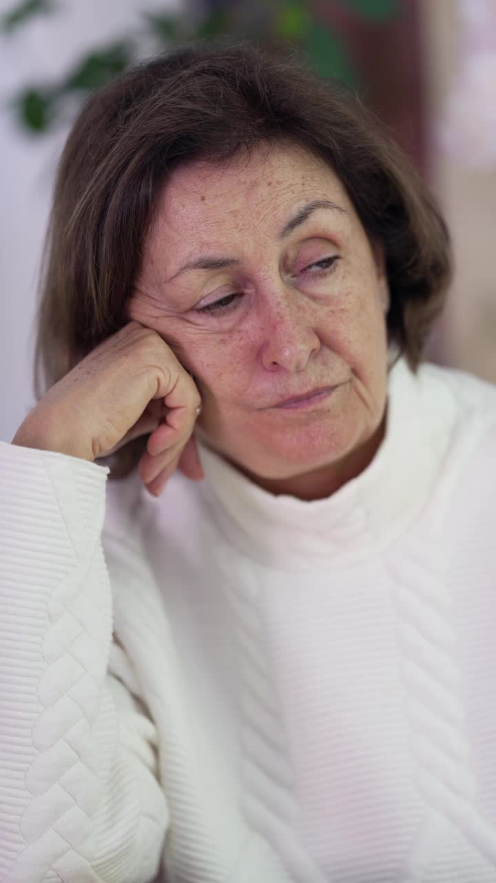 手托下巴沉思沉思的老年妇女，沉思沉思的70多岁的老妇人凝视着远方，心情忧郁视频素材