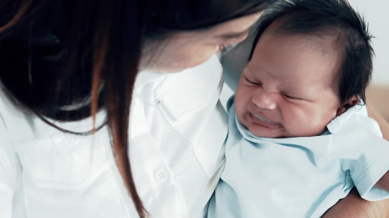 年轻的亚洲母亲用奶瓶喂奶后婴儿的啼哭和停止哭泣。视频下载