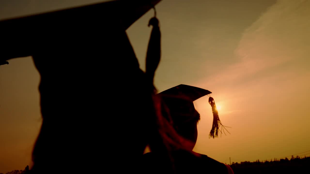 戴着学士帽、穿学士服的毕业生的剪影视频素材