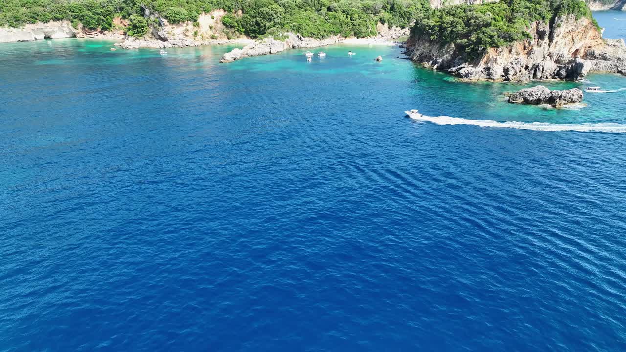 一艘船靠近limni海滩glyko在科孚岛，希腊，与水晶蓝色的海水，鸟瞰图视频素材