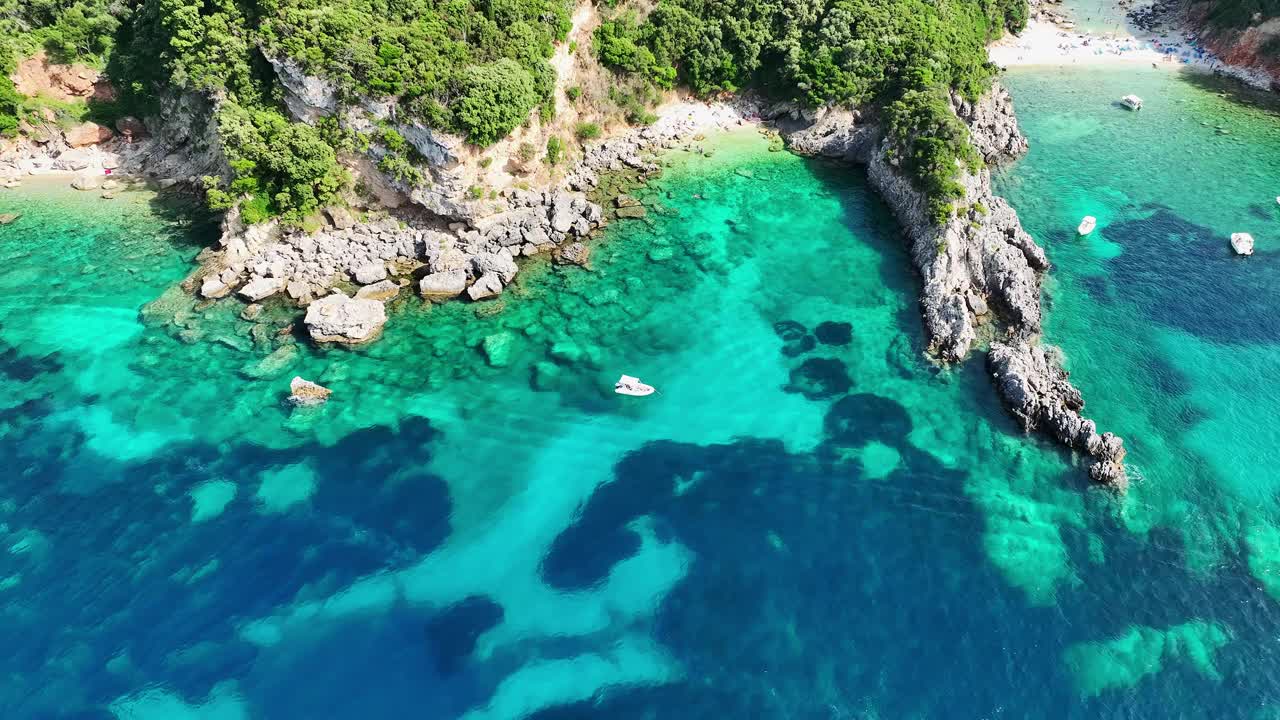 Limni海滩glyko在科孚岛，充满活力的绿松石水域拥抱岩石海岸线，希腊，夏季氛围，鸟瞰图视频素材