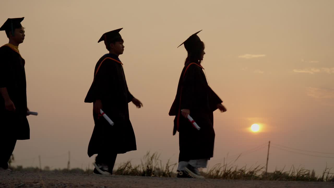 夕阳西下，一群毕业生走过一片田野视频素材