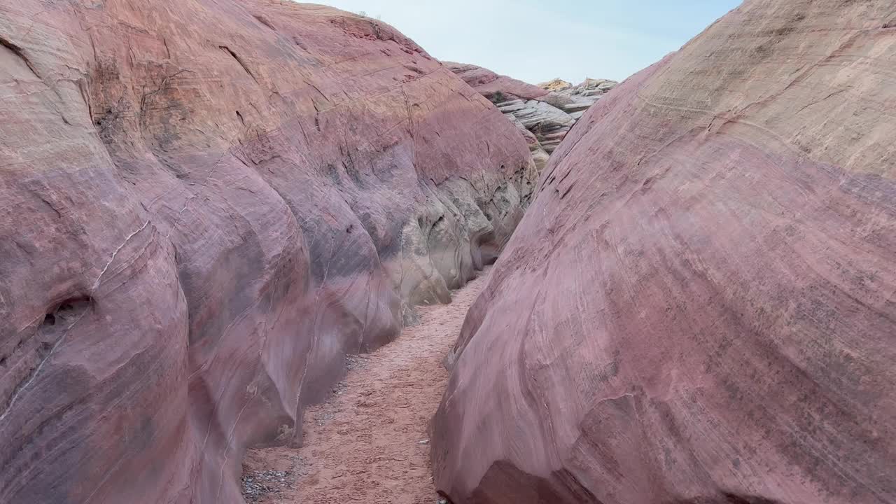 徒步旅行者的视角或POV行走在一个柔和的粉红色槽峡谷在火谷州立公园视频素材